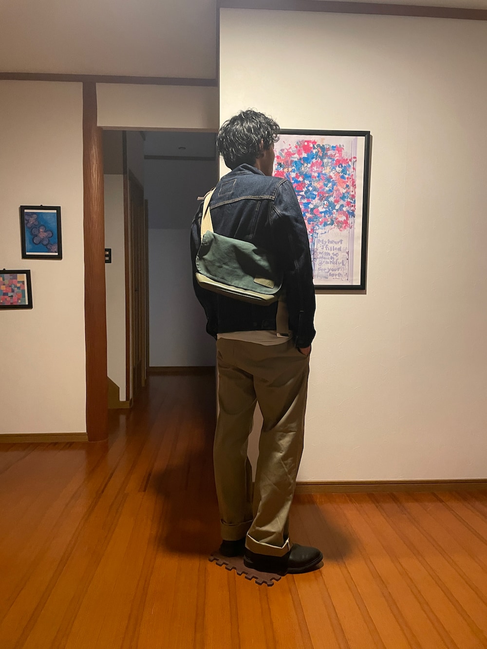 ブルー系のデニムジャケット、ベージュ系のチノパンツを着用したメンズの春コーディネートの2枚目の写真