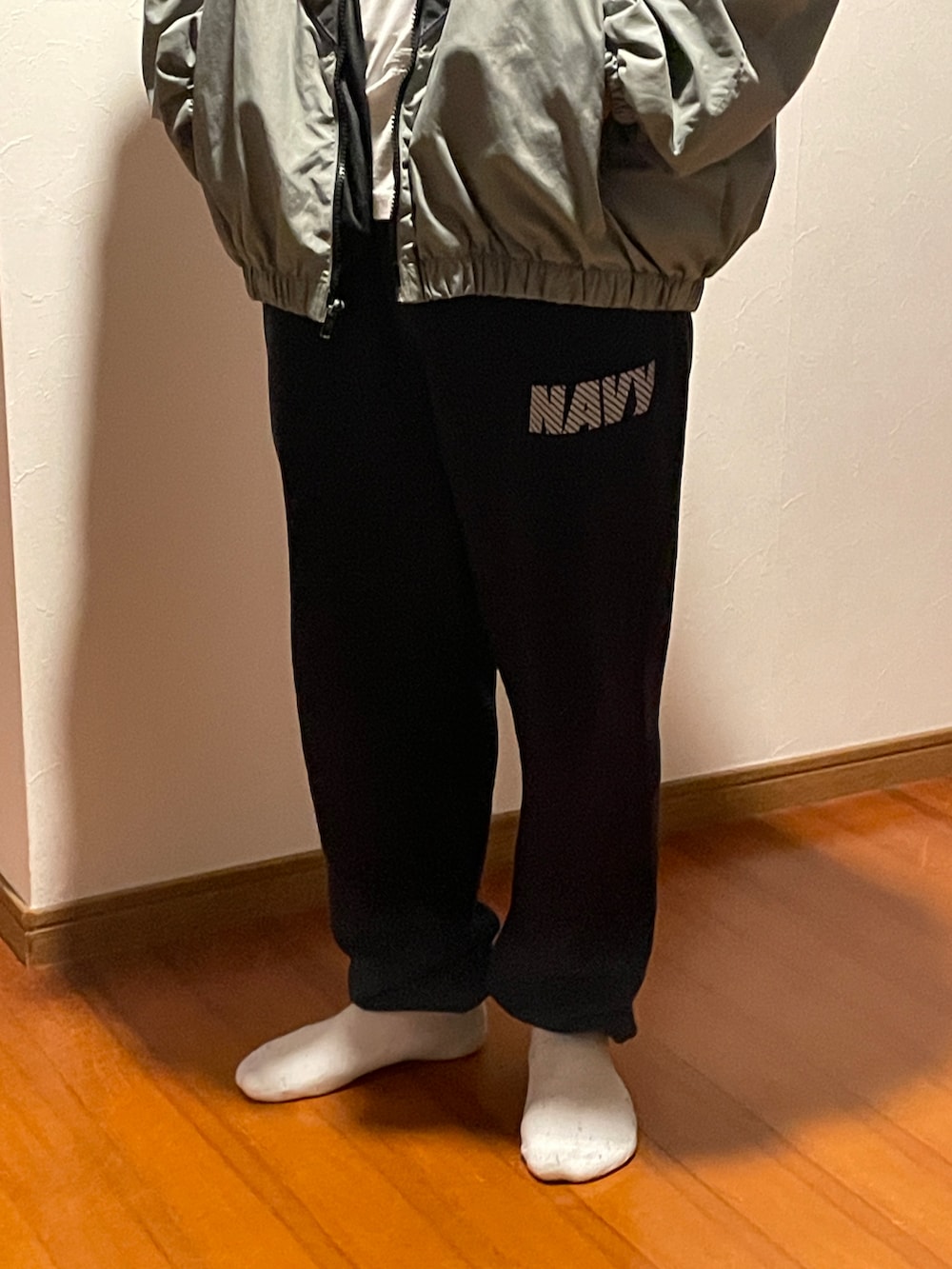 グレー系のミリタリージャケット、ブルー系のスウェットパンツを着用したメンズの秋コーディネートの2枚目の写真