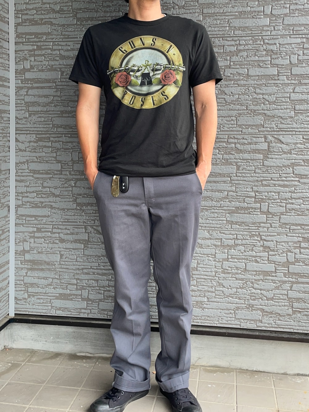 ベージュ系のチノパンツ、ブラック系のスニーカー、ブラック系のTシャツ/カットソーを着用したメンズの夏コーディネートの2枚目の写真