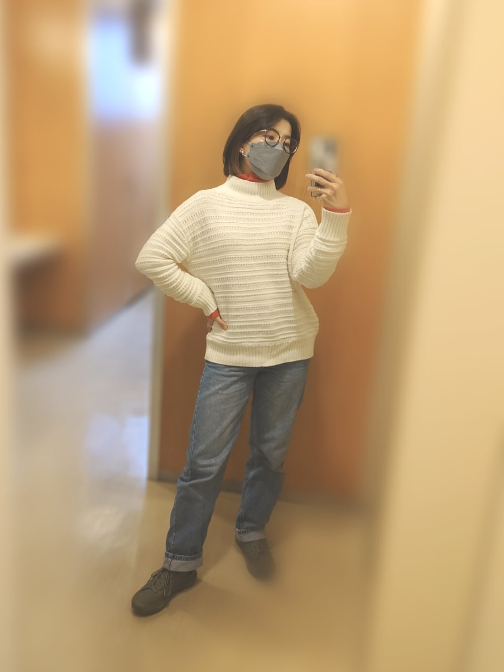 ベージュ系のダウンジャケット/コート、ブラック系のバックパック/リュック、ブルー系のデニムパンツを着用したレディースの冬コーディネートの2枚目の写真