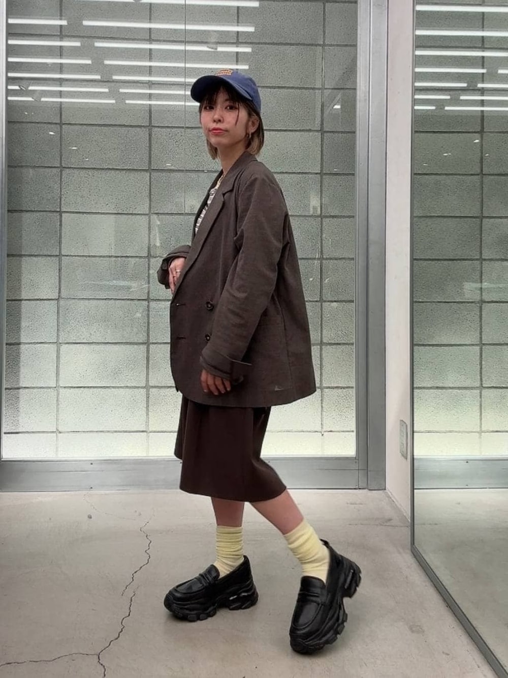 ブラック系のローファー、ホワイト系のTシャツ/カットソー、ブラウン系のスラックスを着用したレディースの春コーディネートの3枚目の写真