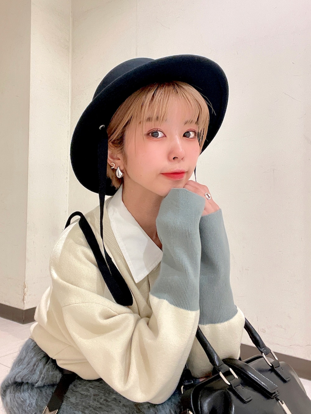 ホワイト系のカーディガン/ボレロ、ブルー系のスカート、ブラック系のパンプスを着用したレディースの冬コーディネートの5枚目の写真