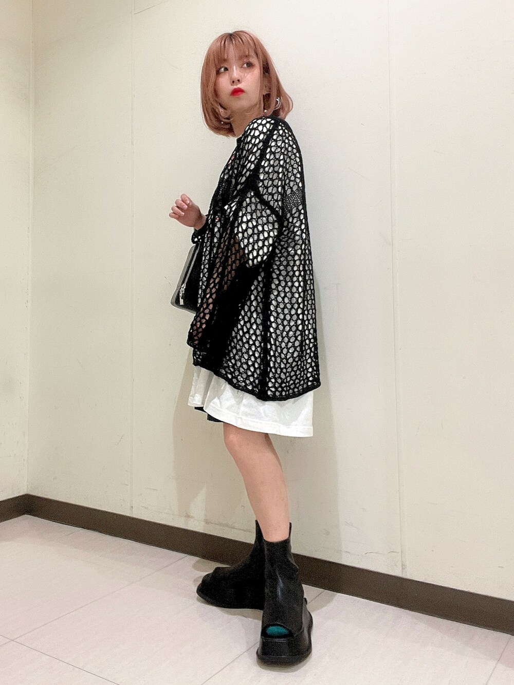 ホワイト系のTシャツ/カットソー、ブラック系のショルダーバッグ、ブラック系のニット/セーターを着用したレディースの春コーディネートの2枚目の写真