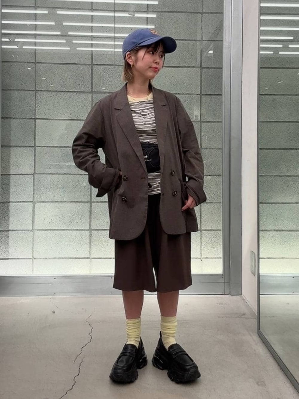 ブラック系のローファー、ホワイト系のTシャツ/カットソー、ブラウン系のスラックスを着用したレディースの春コーディネートの6枚目の写真