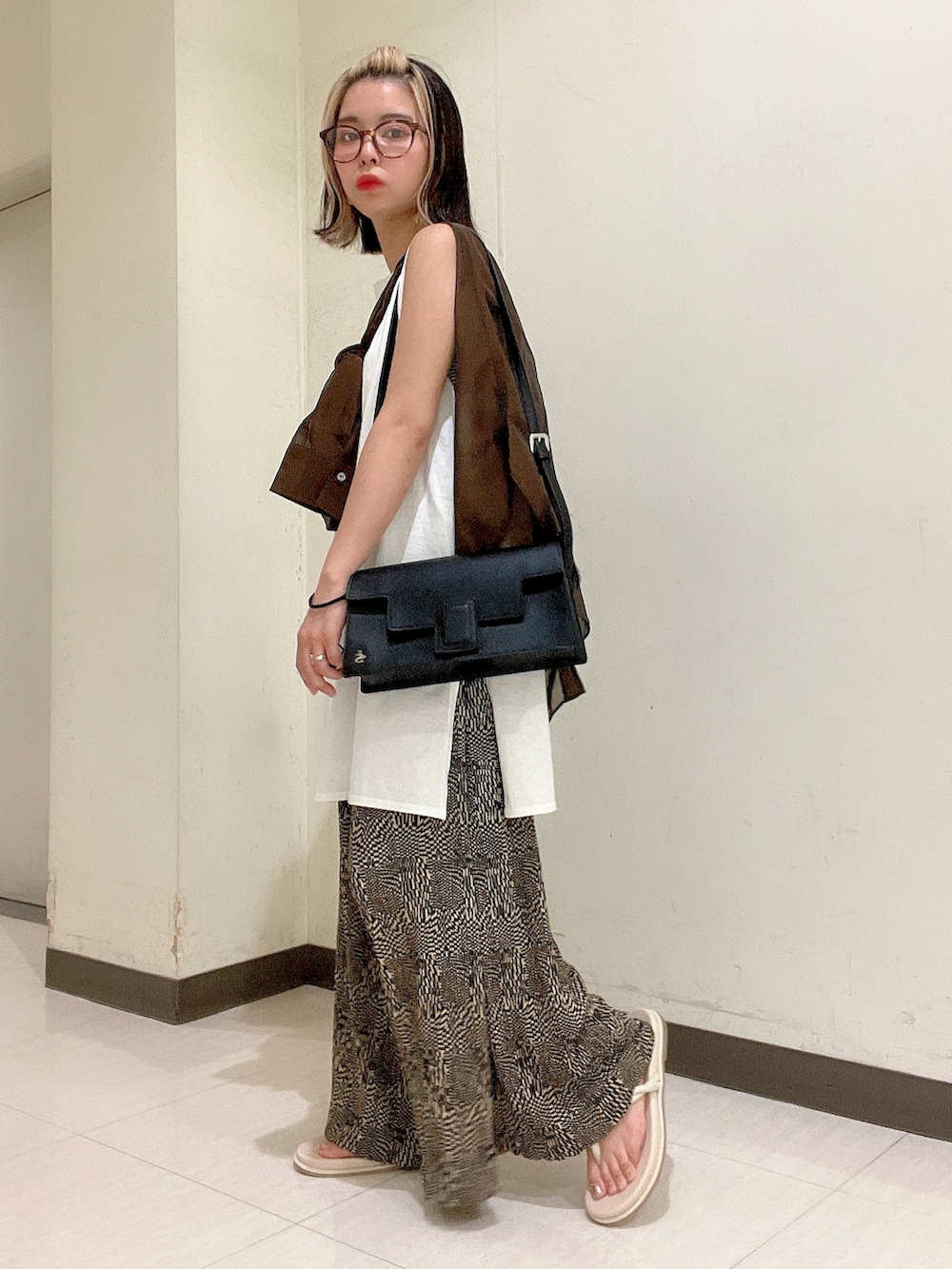 ブラック系のショルダーバッグ、ホワイト系のTシャツ/カットソー、ブラウン系のシャツ/ブラウスを着用したレディースの夏コーディネートの3枚目の写真