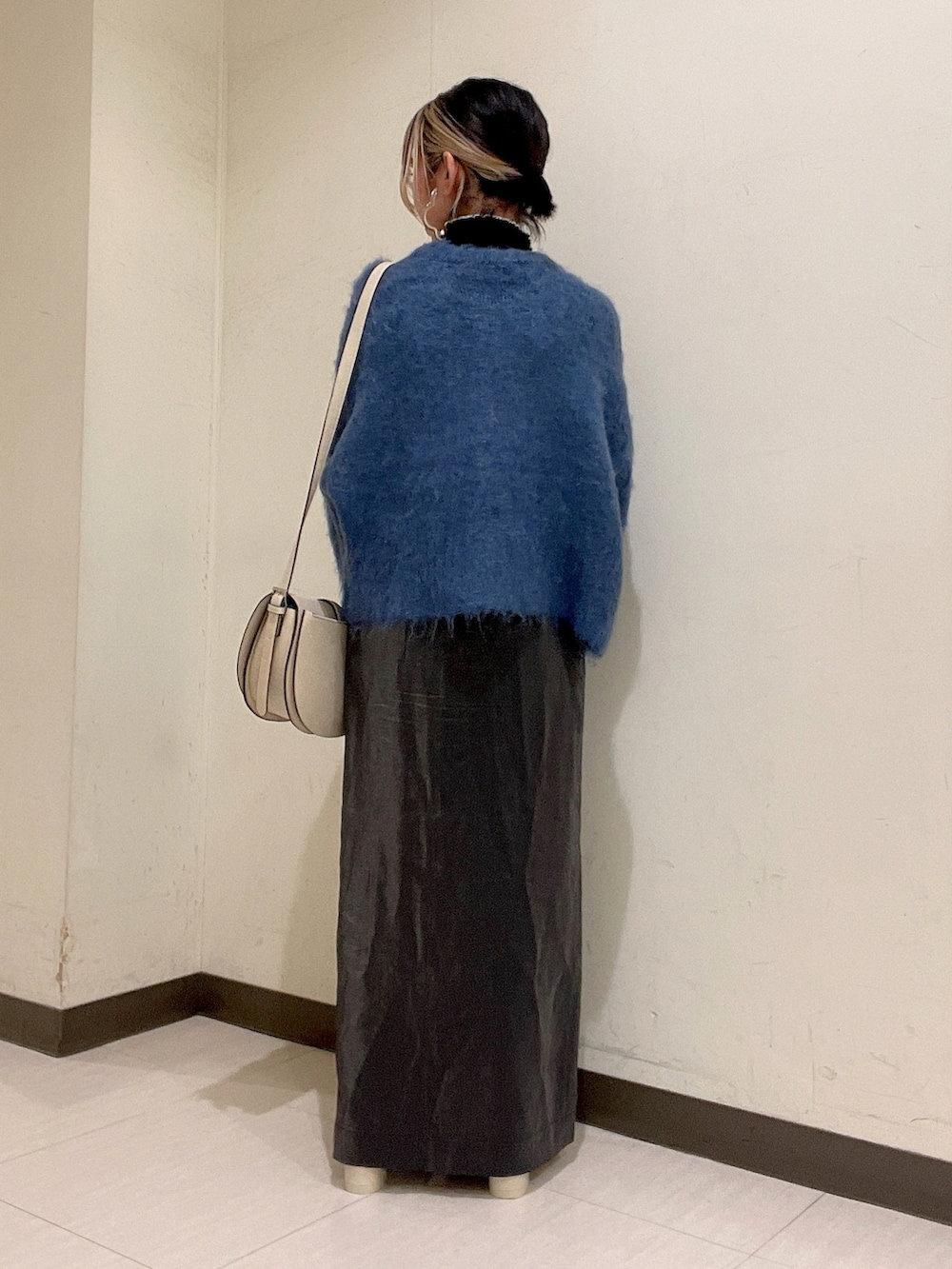 ブルー系のカーディガン/ボレロ、ホワイト系のショルダーバッグ、ブラック系のスカートを着用したレディースの秋コーディネートの3枚目の写真