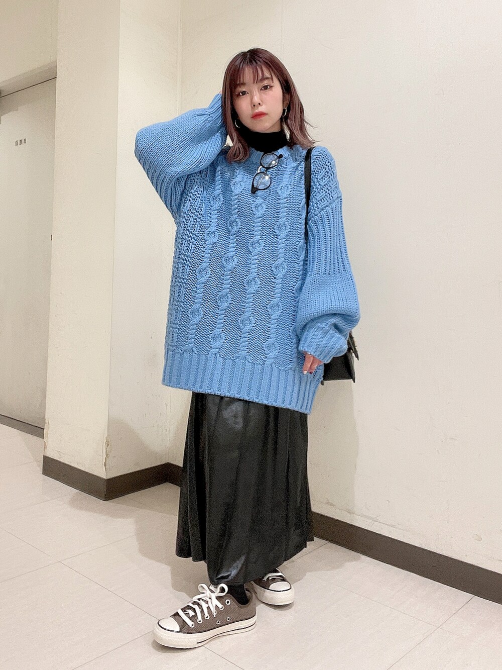 ブルー系のニット/セーター、ブラック系のショルダーバッグ、ブラック系のスカートを着用したレディースの秋コーディネートの3枚目の写真