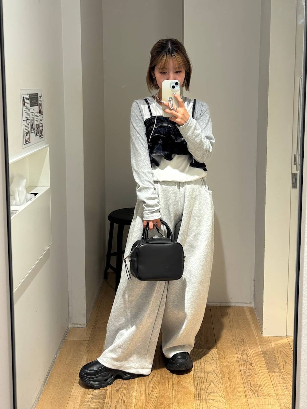 ブラック系のショルダーバッグ、グレー系のスウェットパンツ、ブラック系のローファーを着用したレディースの秋コーディネートの3枚目の写真