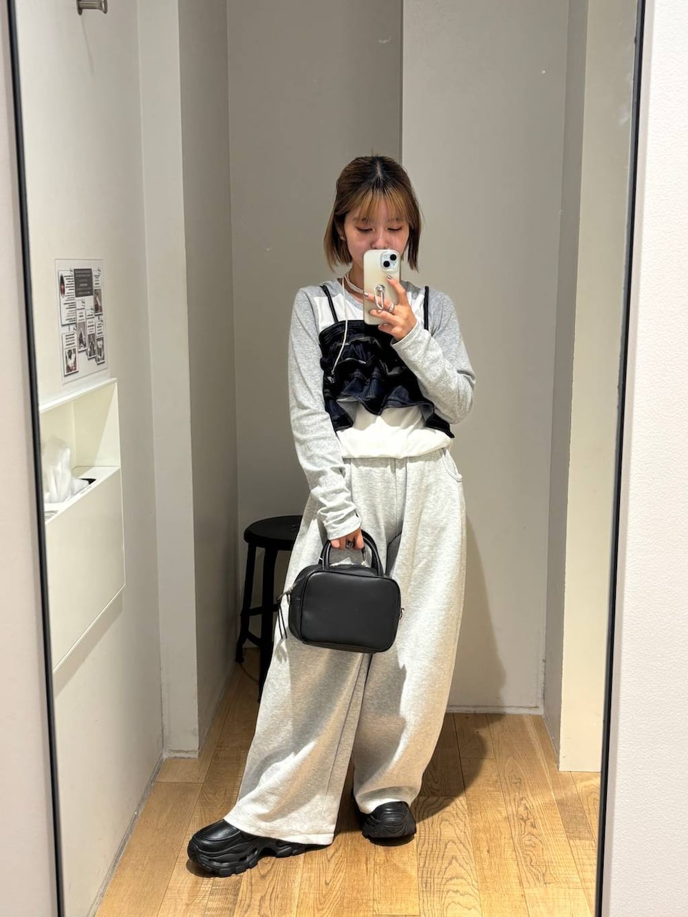 ブラック系のショルダーバッグ、グレー系のスウェットパンツ、ブラック系のローファーを着用したレディースの秋コーディネートの2枚目の写真