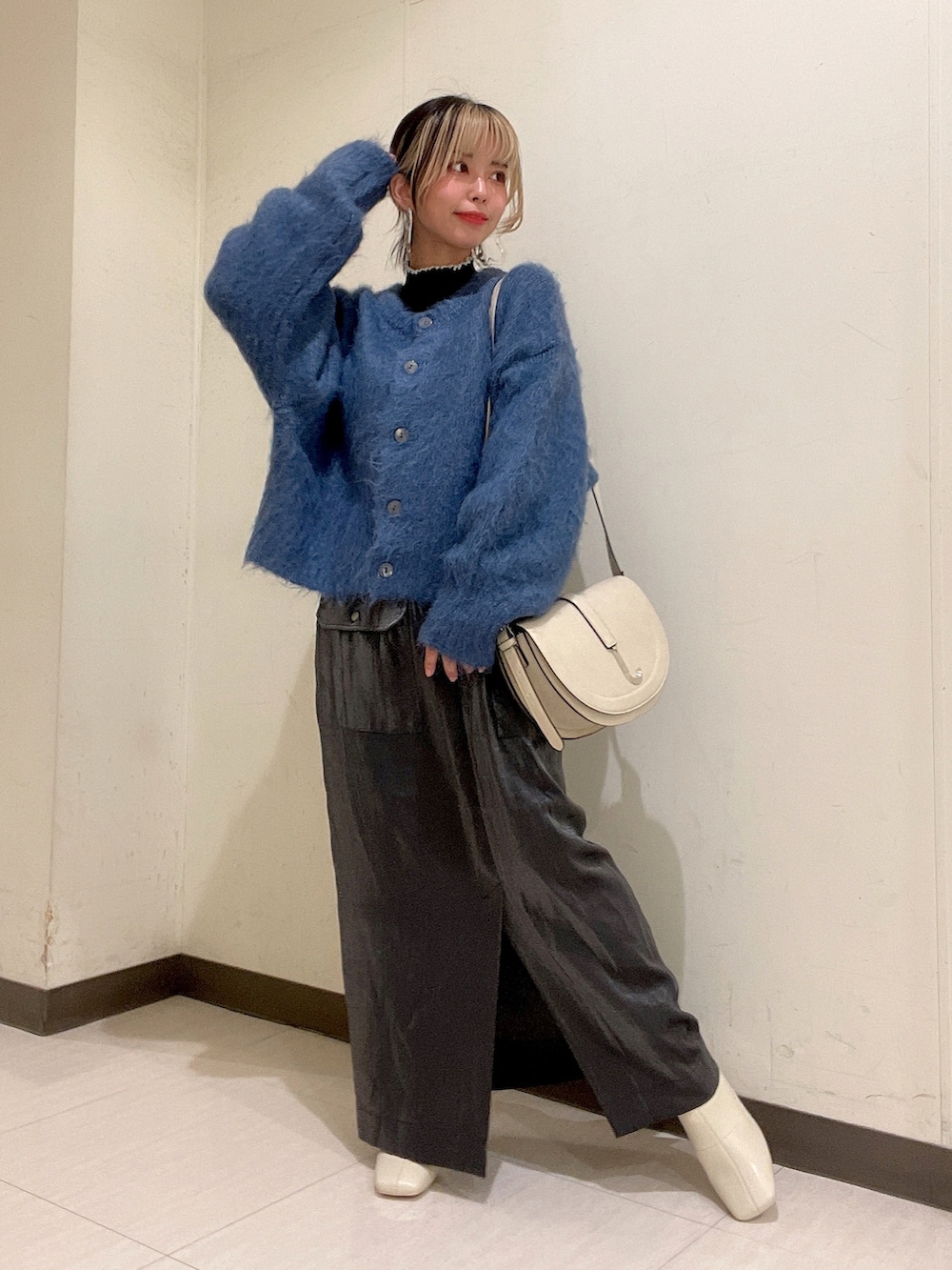 ブルー系のカーディガン/ボレロ、ホワイト系のショルダーバッグ、ブラック系のスカートを着用したレディースの秋コーディネートの2枚目の写真