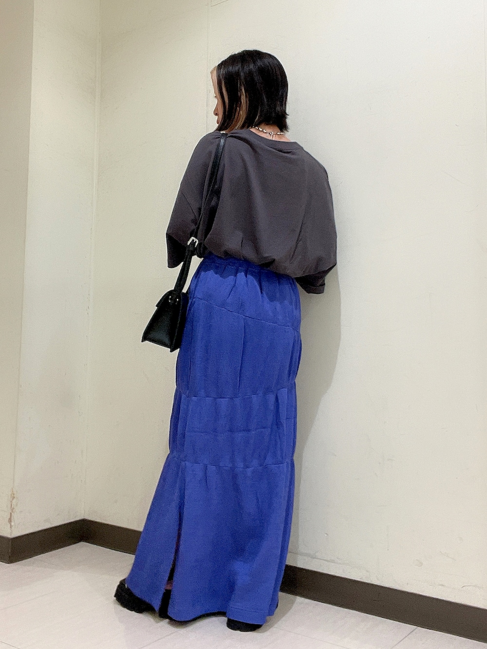 グレー系のTシャツ/カットソー、ブラック系のショルダーバッグ、パープル系のスカートを着用したレディースの夏コーディネートの3枚目の写真