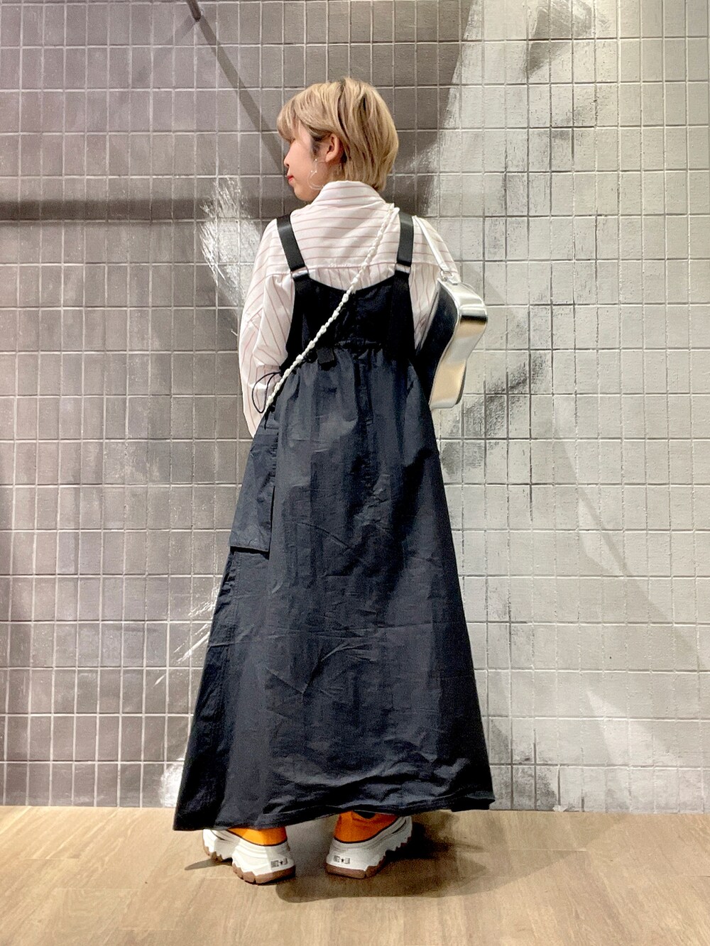 ホワイト系のボストンバッグ、ホワイト系のシャツ/ブラウス、ブラック系のジャンパースカートを着用したレディースの冬コーディネートの3枚目の写真