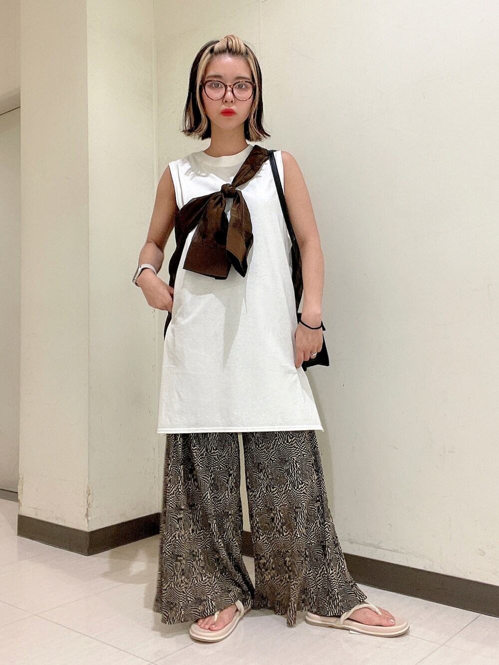 ブラック系のショルダーバッグ、ホワイト系のTシャツ/カットソー、ブラウン系のシャツ/ブラウスを着用したレディースの夏コーディネートの2枚目の写真