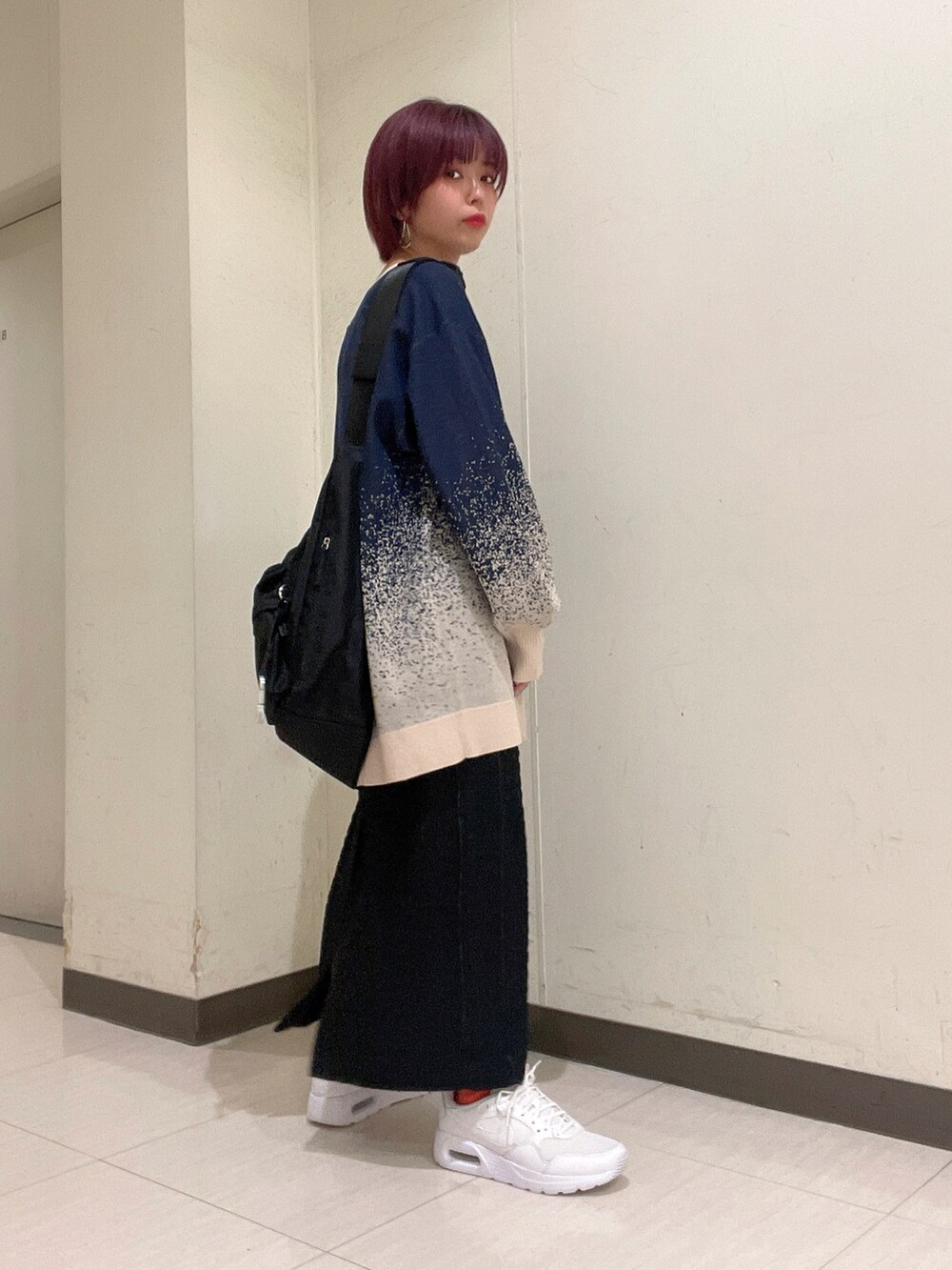 ブルー系のトップス、ブラック系のニット/セーター、ブラック系のボディバッグ/ウエストポーチを着用したレディースの春コーディネートの2枚目の写真