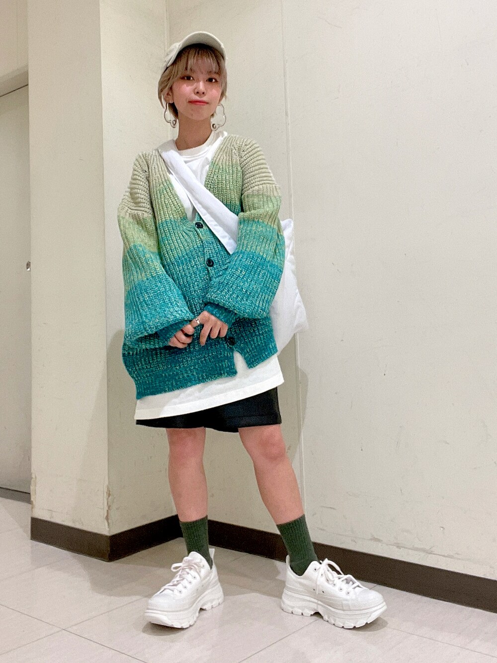 ホワイト系のボディバッグ/ウエストポーチ、ホワイト系のTシャツ/カットソー、グリーン系のカーディガン/ボレロを着用したレディースの冬コーディネートの4枚目の写真
