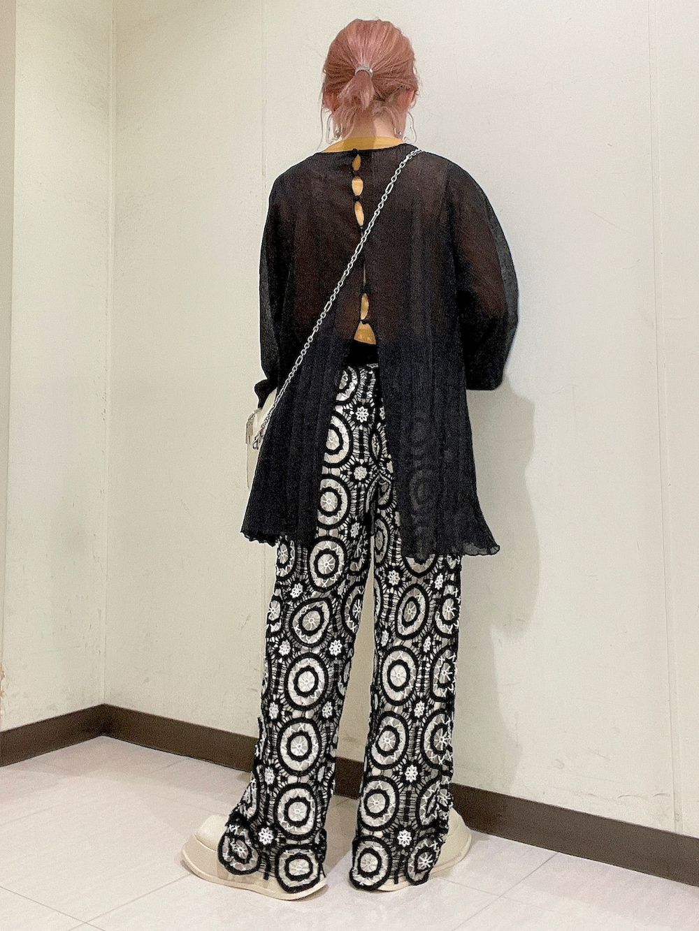 ブラック系のニット/セーター、イエロー系のTシャツ/カットソー、ホワイト系のショルダーバッグを着用したレディースの春コーディネートの4枚目の写真