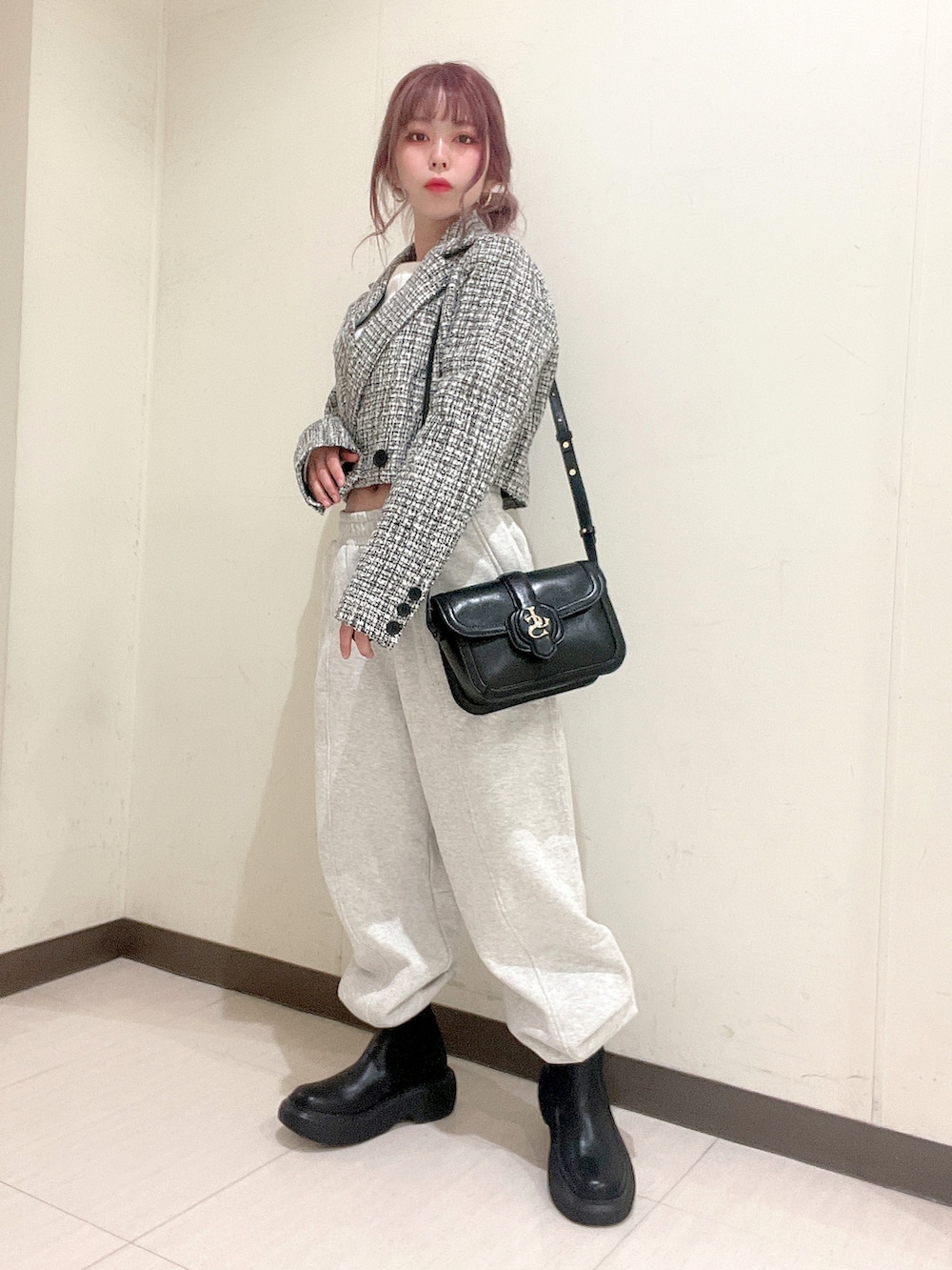 ブラック系のテーラードジャケット、ホワイト系のTシャツ/カットソー、グレー系のスウェットパンツを着用したレディースの春コーディネートの2枚目の写真