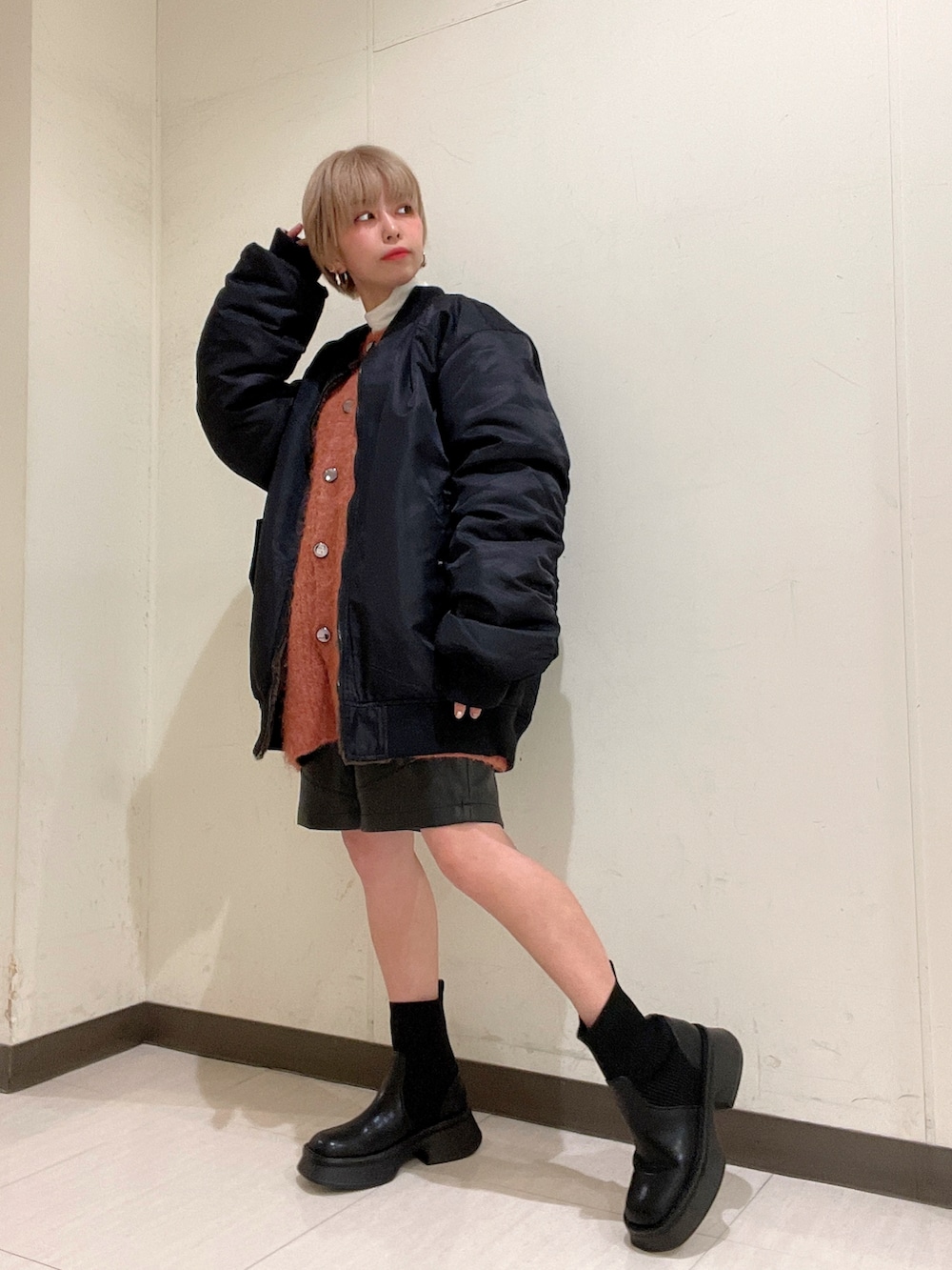 ブラック系のMA-1、オレンジ系のカーディガン/ボレロ、ホワイト系のTシャツ/カットソーを着用したレディースの冬コーディネートの4枚目の写真