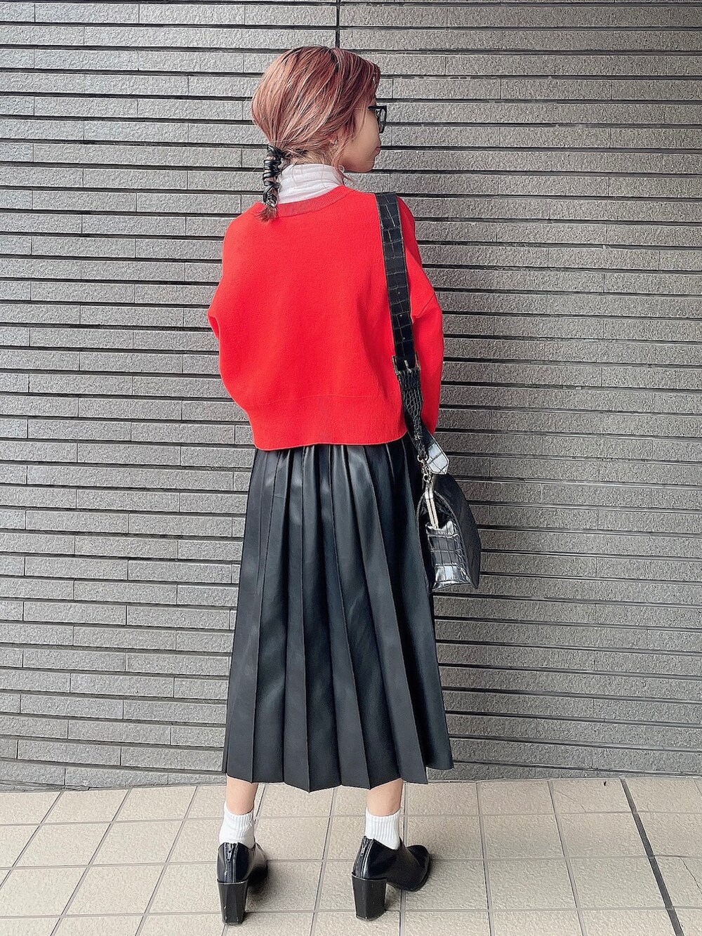 オレンジ系のカーディガン/ボレロ、ブラック系のスカート、ブラック系のパンプスを着用したレディースの秋コーディネートの3枚目の写真