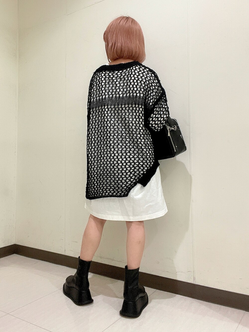 ホワイト系のTシャツ/カットソー、ブラック系のショルダーバッグ、ブラック系のニット/セーターを着用したレディースの春コーディネートの3枚目の写真