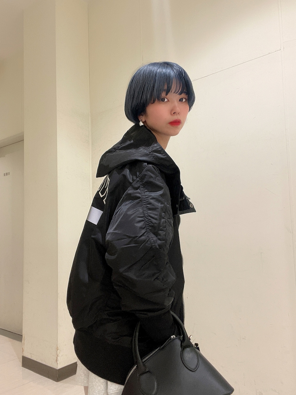 ブラック系のMA-1、ブラック系のサンダル、ホワイト系のスウェットを着用したレディースの冬コーディネートの5枚目の写真