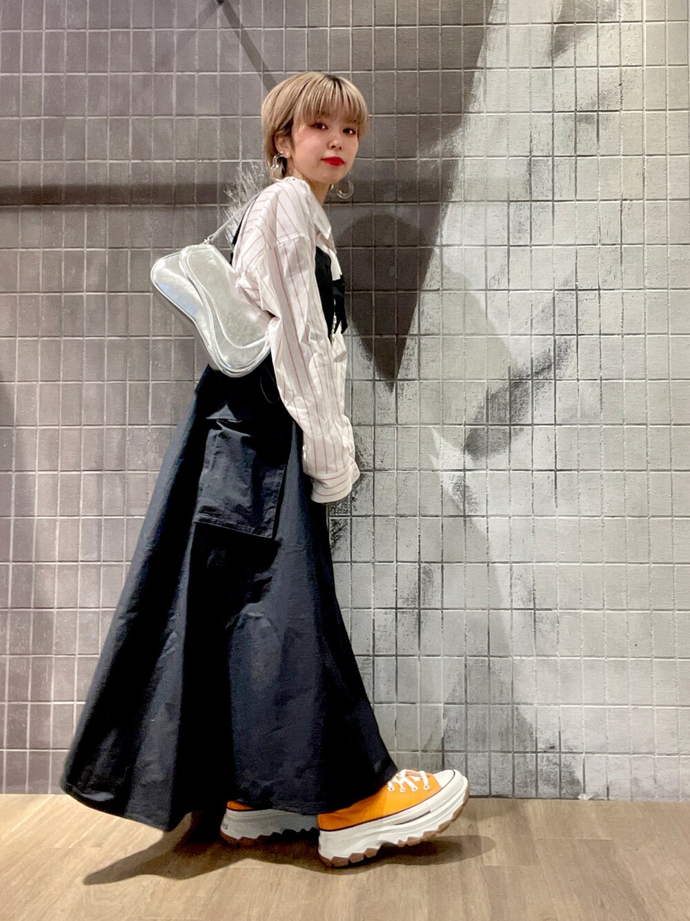 ホワイト系のボストンバッグ、ホワイト系のシャツ/ブラウス、ブラック系のジャンパースカートを着用したレディースの冬コーディネートの4枚目の写真