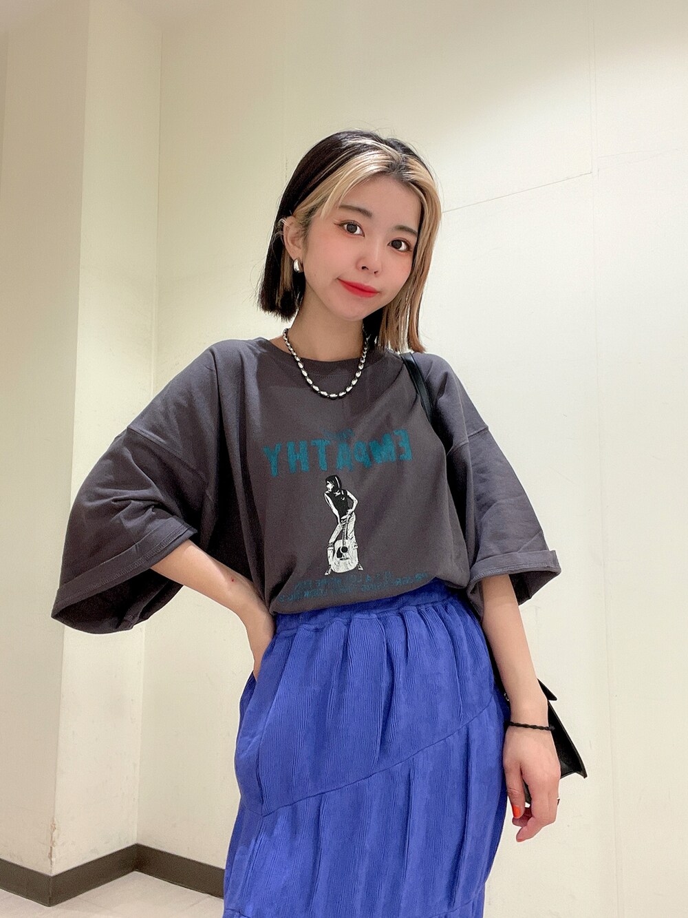 グレー系のTシャツ/カットソー、ブラック系のショルダーバッグ、パープル系のスカートを着用したレディースの夏コーディネートの4枚目の写真