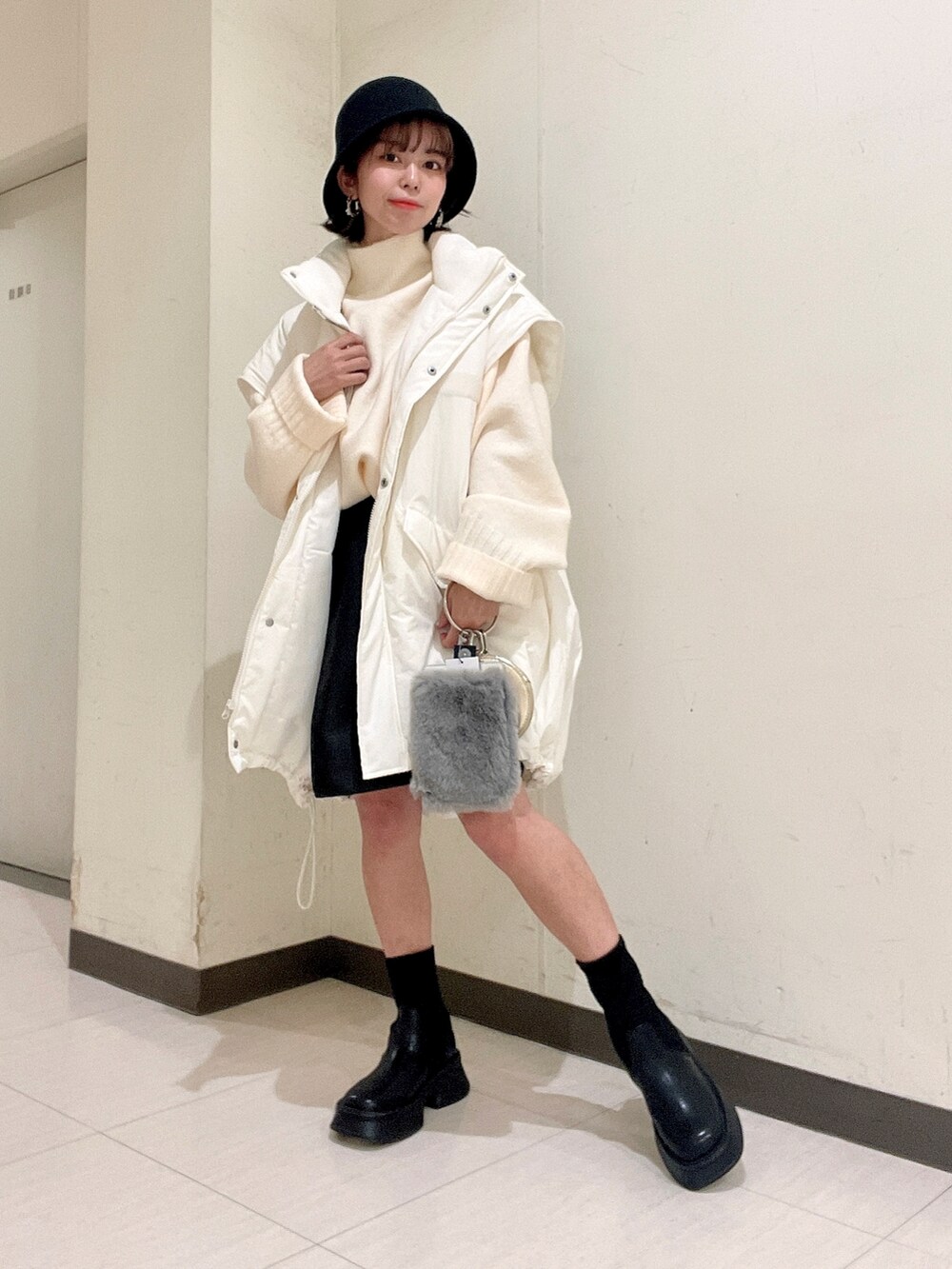 ホワイト系のニット/セーター、ブラック系のその他パンツ、ホワイト系のナイロンジャケットを着用したレディースの秋コーディネートの5枚目の写真