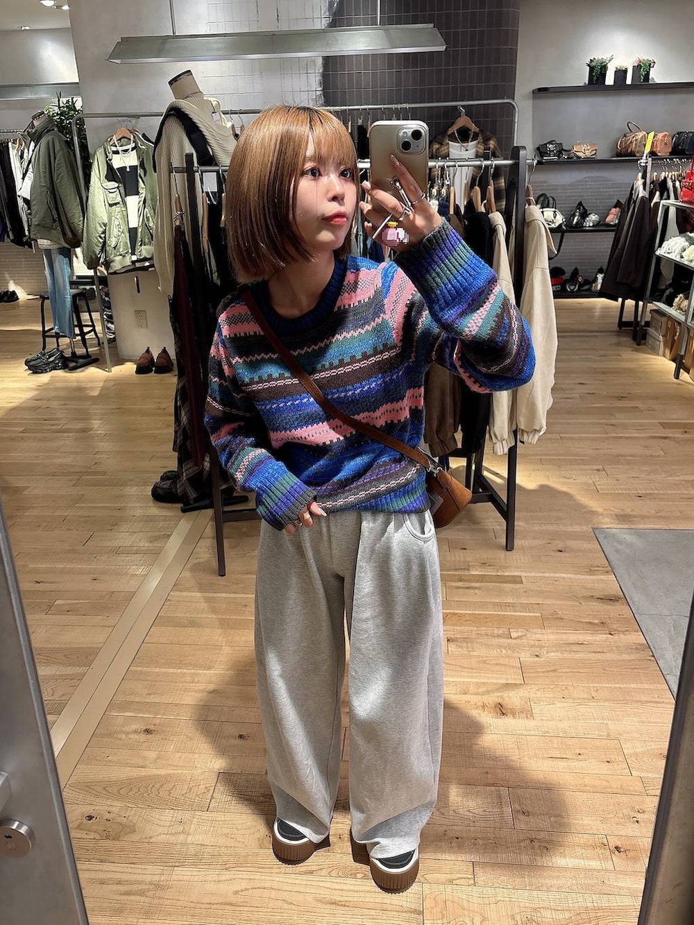 グレー系のスウェットパンツ、ブラウン系のボストンバッグ、その他のニット/セーターを着用したレディースの秋コーディネートの3枚目の写真