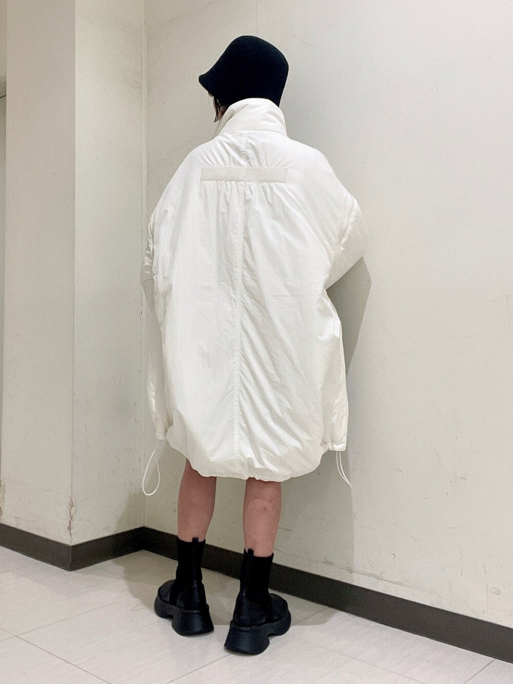 ホワイト系のニット/セーター、ブラック系のその他パンツ、ホワイト系のナイロンジャケットを着用したレディースの秋コーディネートの3枚目の写真