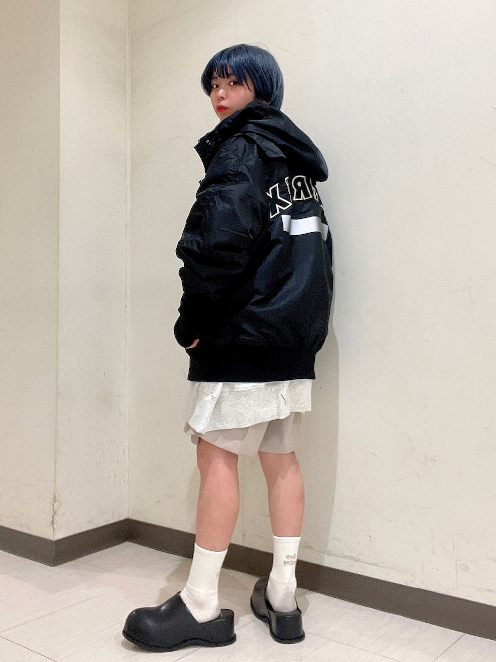 ブラック系のMA-1、ブラック系のサンダル、ホワイト系のスウェットを着用したレディースの冬コーディネートの2枚目の写真