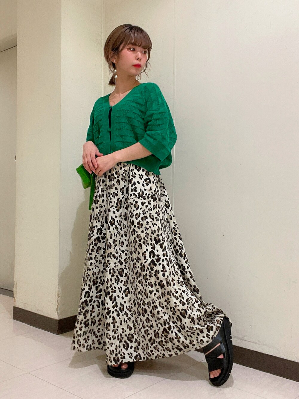 グリーン系のカーディガン/ボレロ、その他のスカート、ブラック系のサンダルを着用したレディースの春コーディネートの2枚目の写真