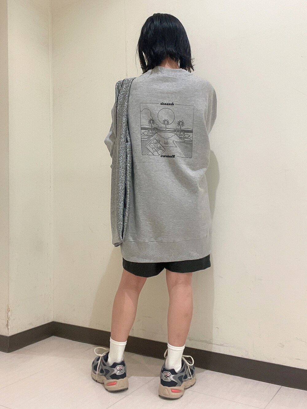 グレー系のスウェット、シルバー系のトートバッグ、ブラック系のその他パンツを着用したレディースの秋コーディネートの2枚目の写真