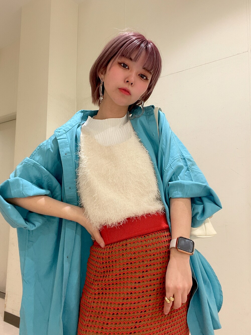 オレンジ系のスカート、ブルー系のシャツ/ブラウス、ホワイト系のショルダーバッグを着用したレディースの春コーディネートの4枚目の写真