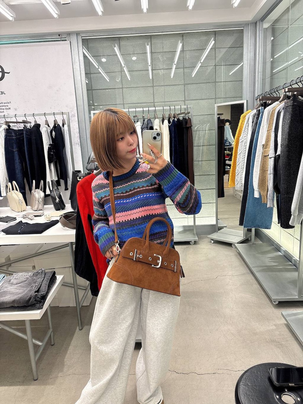 グレー系のスウェットパンツ、ブラウン系のボストンバッグ、その他のニット/セーターを着用したレディースの秋コーディネートの4枚目の写真