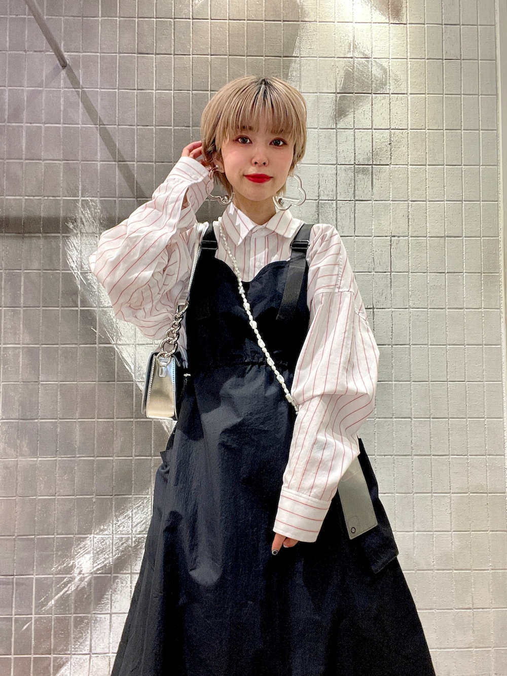 ホワイト系のボストンバッグ、ホワイト系のシャツ/ブラウス、ブラック系のジャンパースカートを着用したレディースの冬コーディネートの5枚目の写真