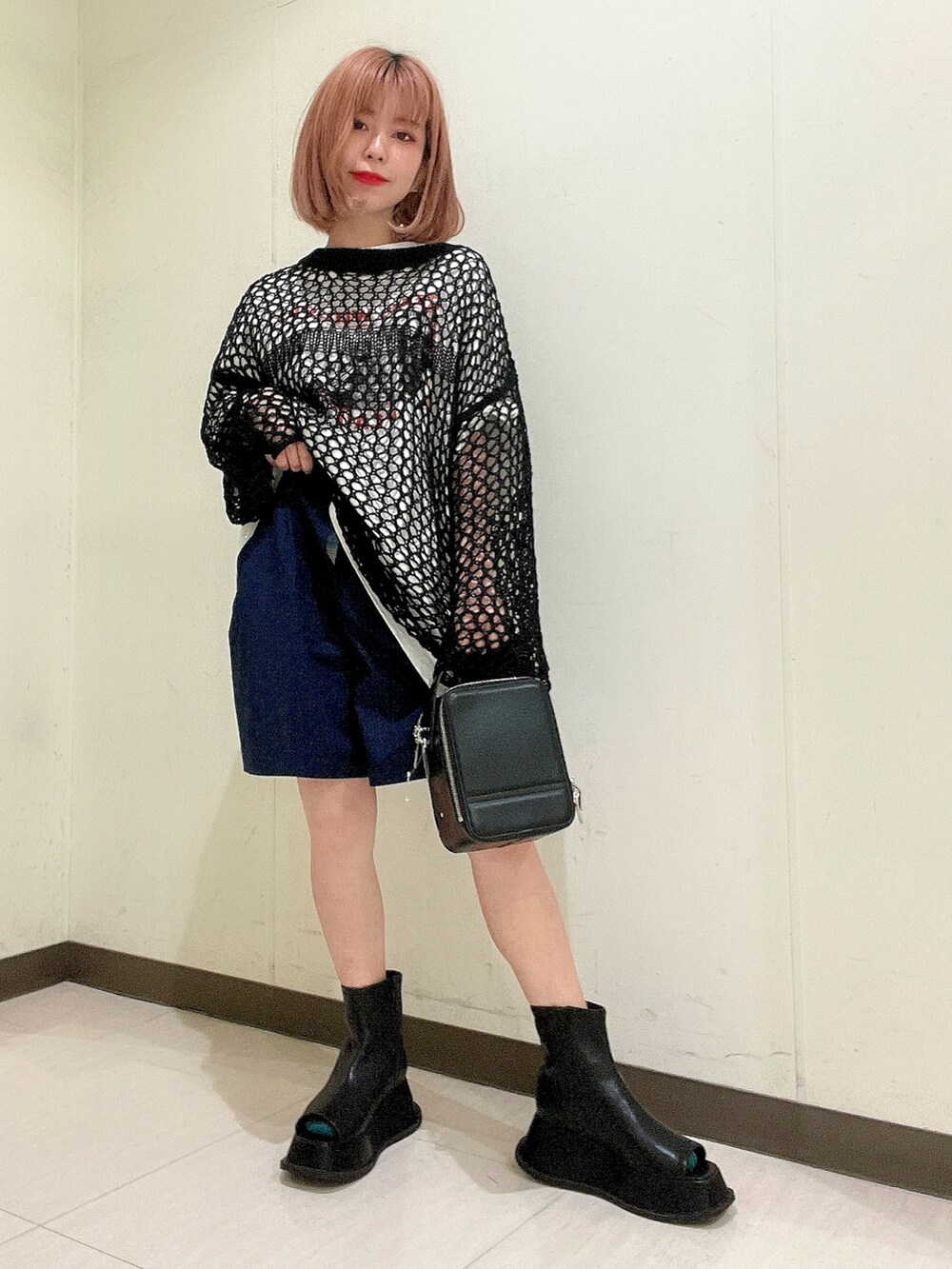 ホワイト系のTシャツ/カットソー、ブラック系のショルダーバッグ、ブラック系のニット/セーターを着用したレディースの春コーディネートの4枚目の写真