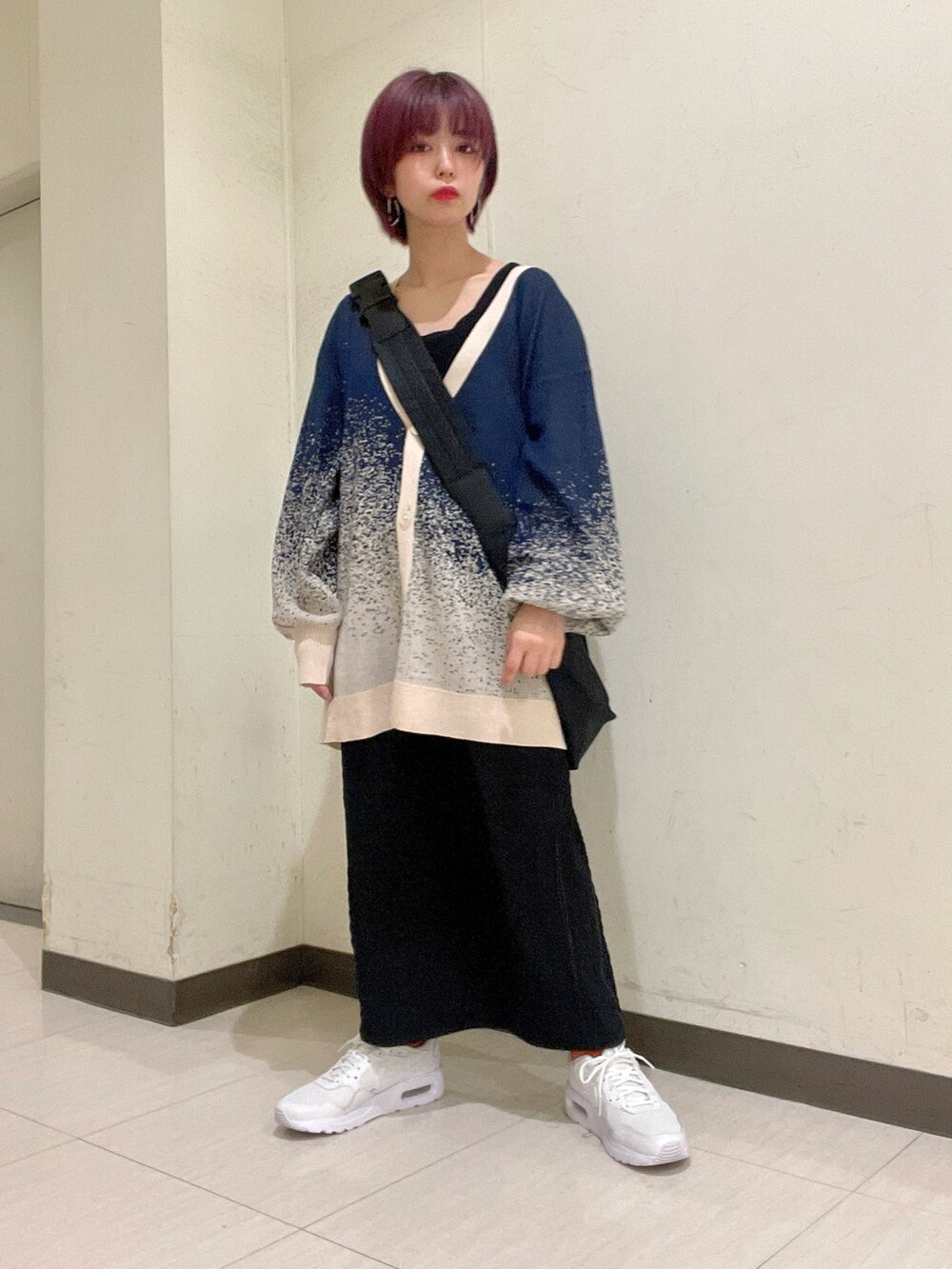 ブルー系のトップス、ブラック系のニット/セーター、ブラック系のボディバッグ/ウエストポーチを着用したレディースの春コーディネートの4枚目の写真