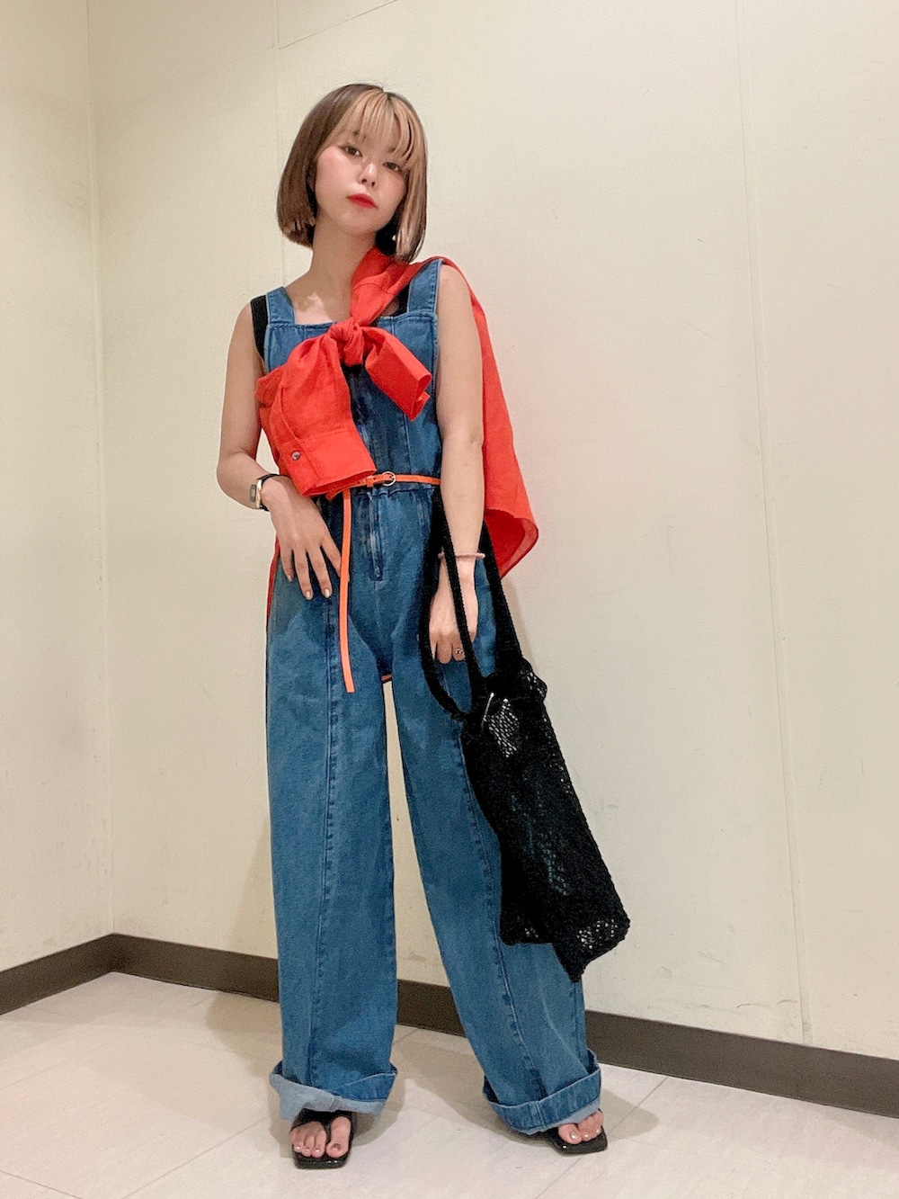 ブルー系のサロペット/オーバーオール、オレンジ系のシャツ/ブラウス、ブラック系のニット/セーターを着用したレディースの夏コーディネートの3枚目の写真