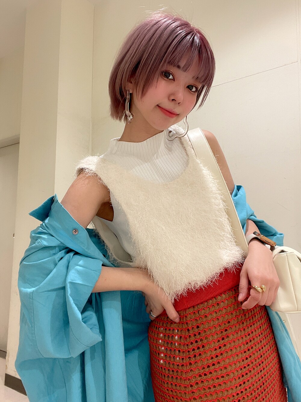 オレンジ系のスカート、ブルー系のシャツ/ブラウス、ホワイト系のショルダーバッグを着用したレディースの春コーディネートの5枚目の写真