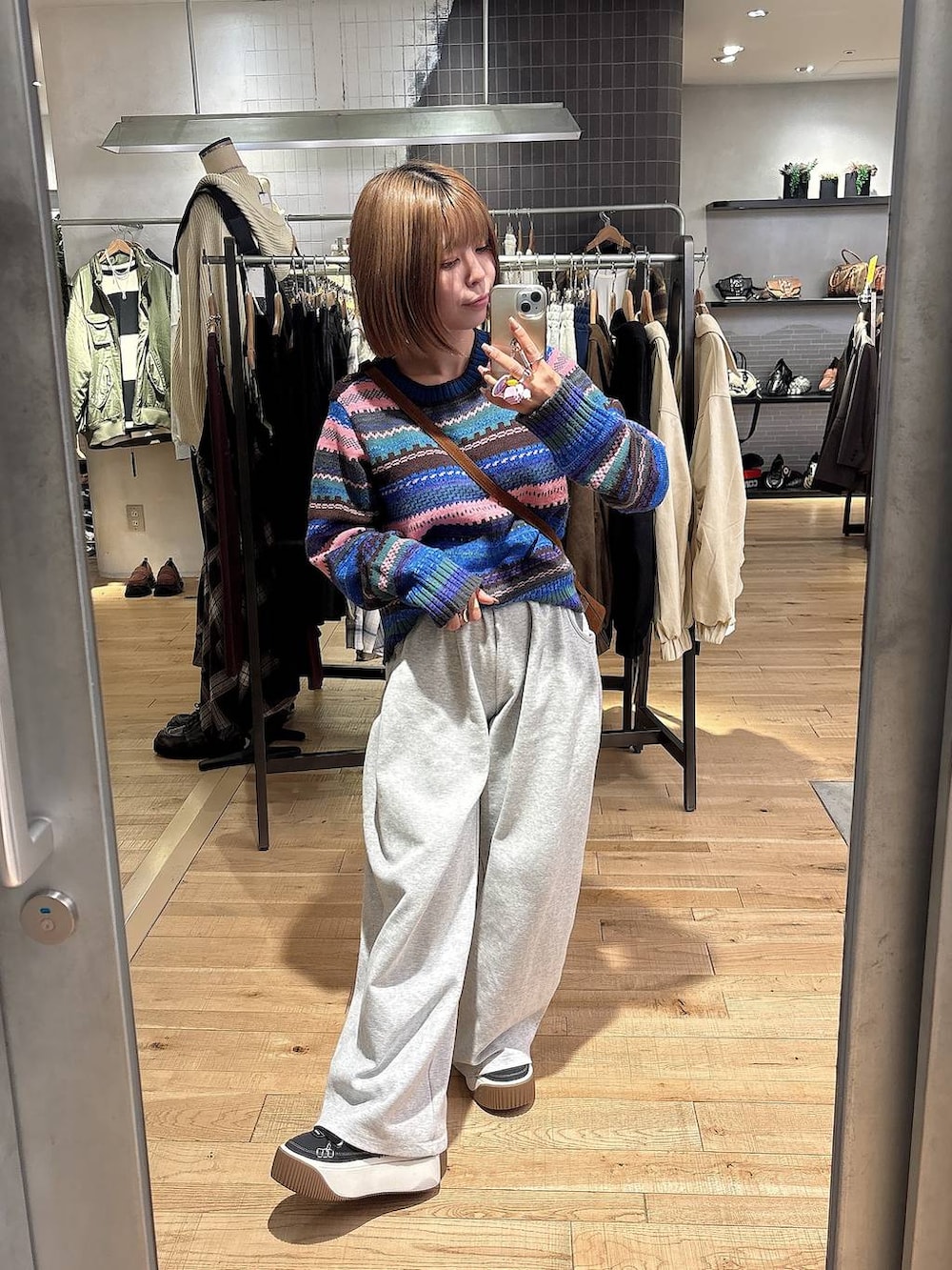 グレー系のスウェットパンツ、ブラウン系のボストンバッグ、その他のニット/セーターを着用したレディースの秋コーディネートの2枚目の写真