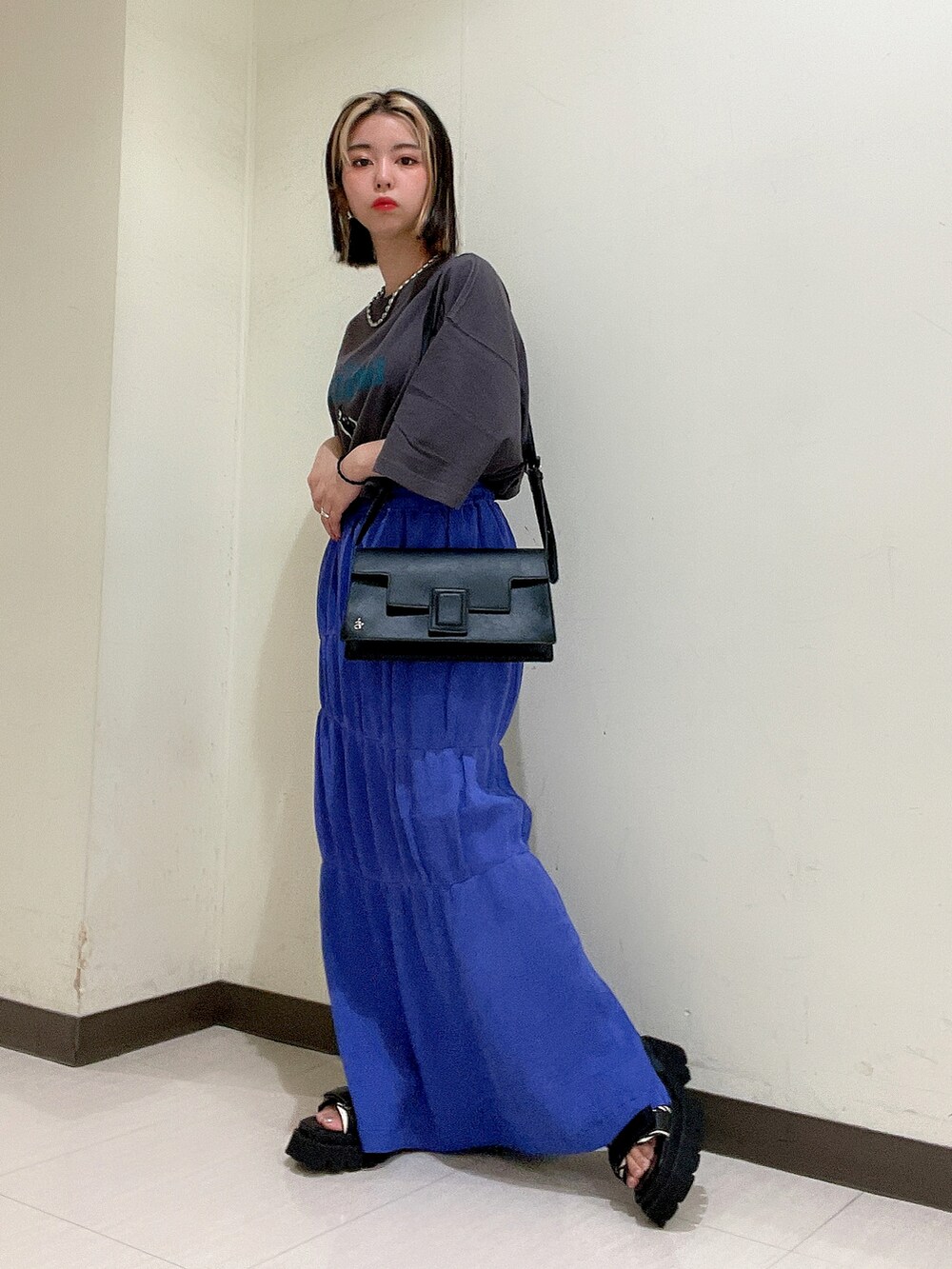 グレー系のTシャツ/カットソー、ブラック系のショルダーバッグ、パープル系のスカートを着用したレディースの夏コーディネートの2枚目の写真