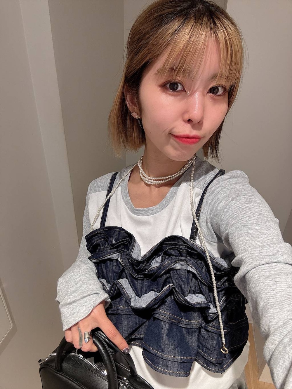 ブラック系のショルダーバッグ、グレー系のスウェットパンツ、ブラック系のローファーを着用したレディースの秋コーディネートの4枚目の写真