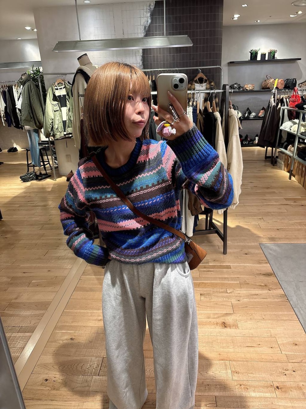 グレー系のスウェットパンツ、ブラウン系のボストンバッグ、その他のニット/セーターを着用したレディースの秋コーディネートの5枚目の写真