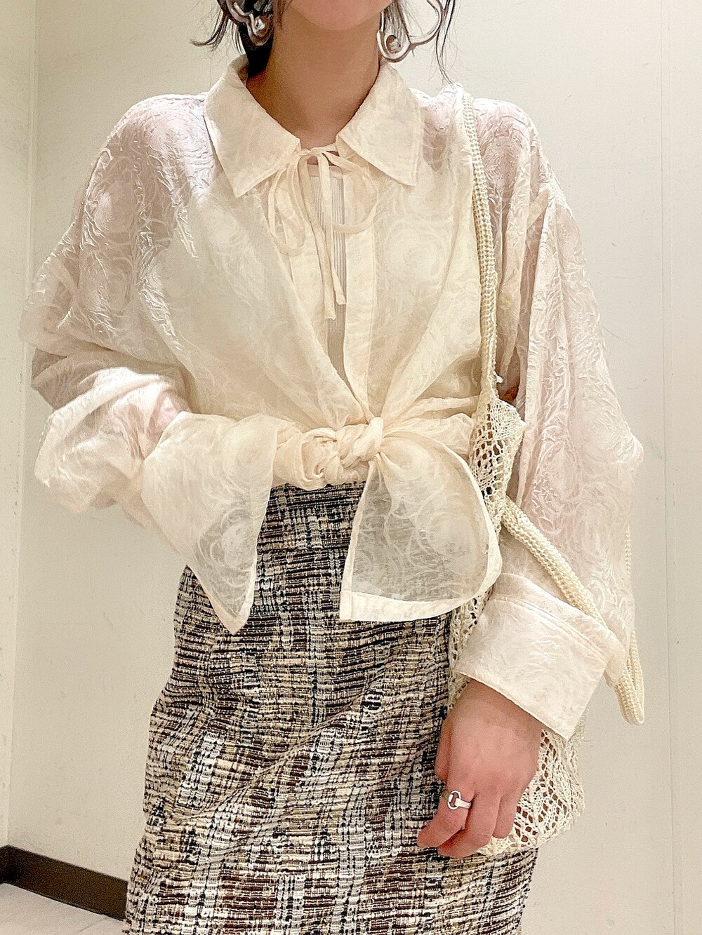 ベージュ系のシャツ/ブラウス、ホワイト系のキャミソール、ホワイト系のトートバッグを着用したレディースの春コーディネートの5枚目の写真