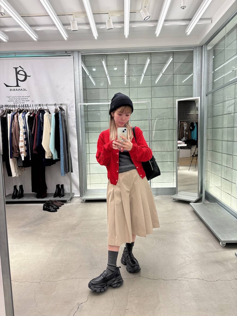 ブラック系のローファー、ブラック系のボストンバッグ、ベージュ系のその他パンツを着用したレディースの春コーディネートの3枚目の写真