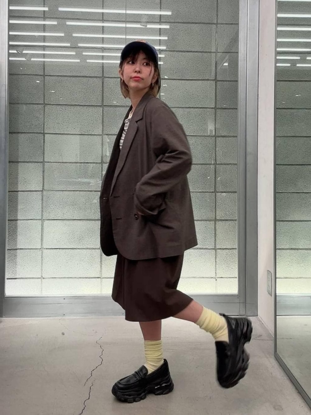 ブラック系のローファー、ホワイト系のTシャツ/カットソー、ブラウン系のスラックスを着用したレディースの春コーディネートの4枚目の写真