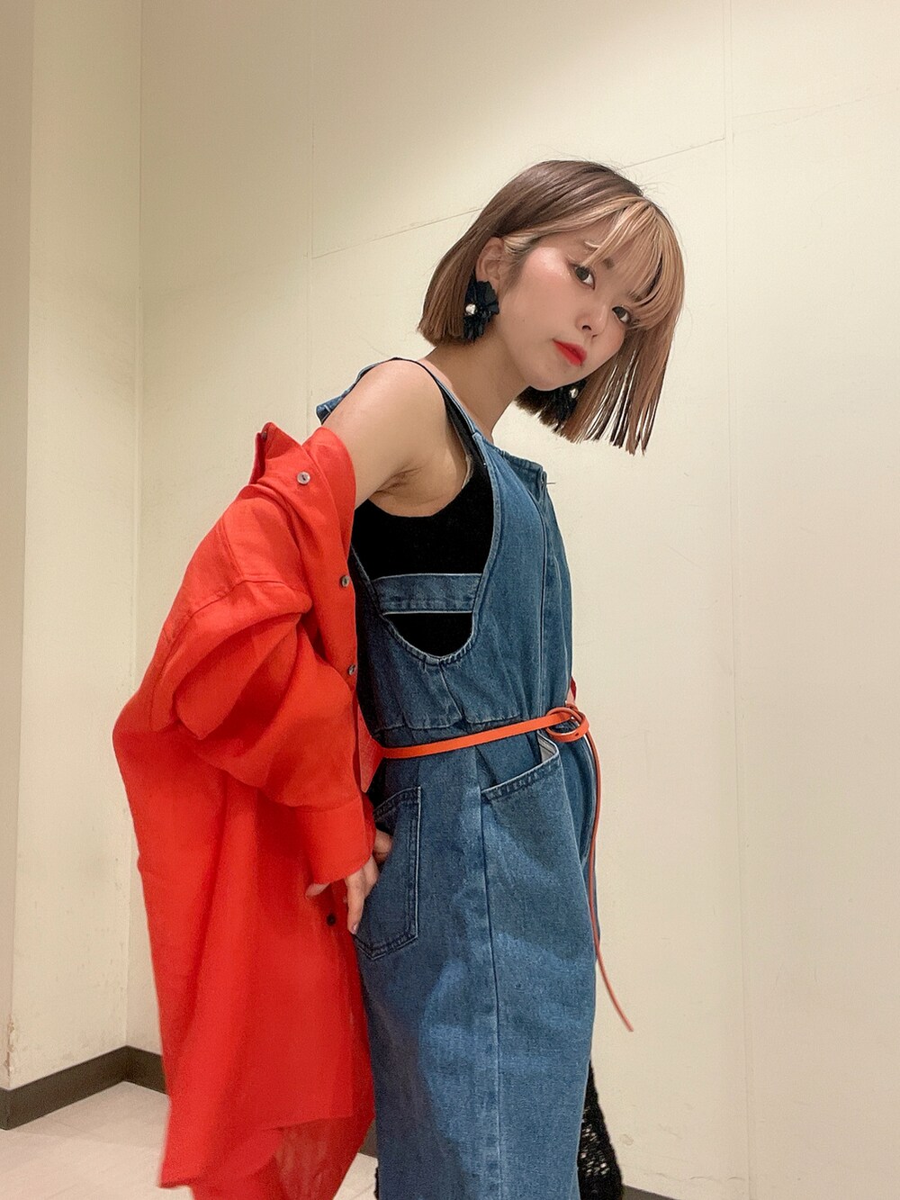 ブルー系のサロペット/オーバーオール、オレンジ系のシャツ/ブラウス、ブラック系のニット/セーターを着用したレディースの夏コーディネートの4枚目の写真