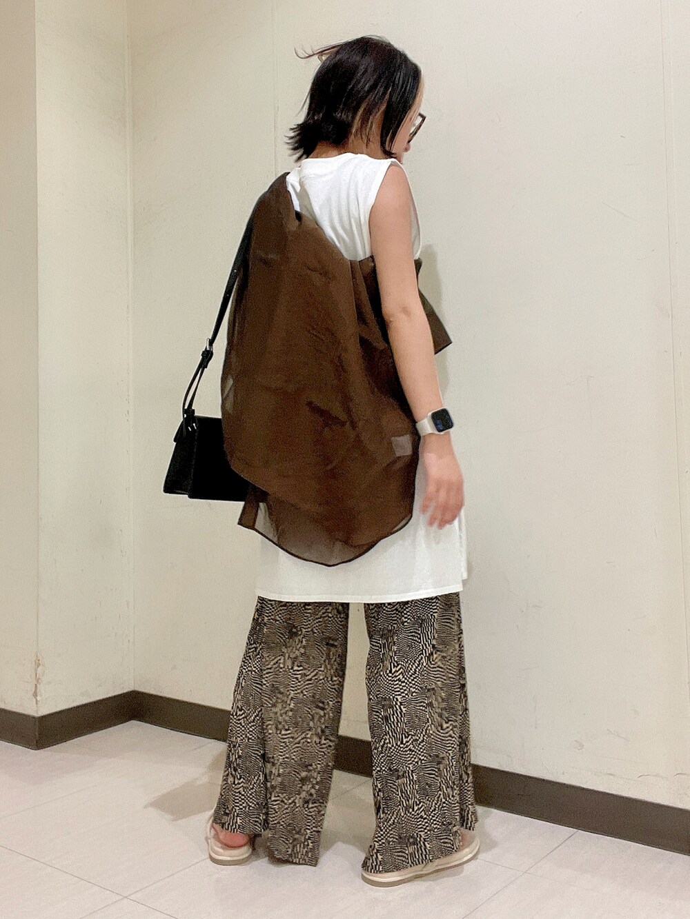 ブラック系のショルダーバッグ、ホワイト系のTシャツ/カットソー、ブラウン系のシャツ/ブラウスを着用したレディースの夏コーディネートの4枚目の写真