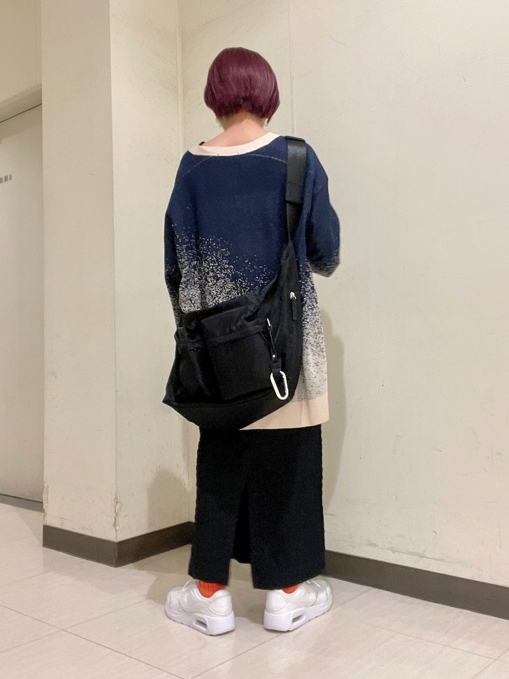 ブルー系のトップス、ブラック系のニット/セーター、ブラック系のボディバッグ/ウエストポーチを着用したレディースの春コーディネートの3枚目の写真